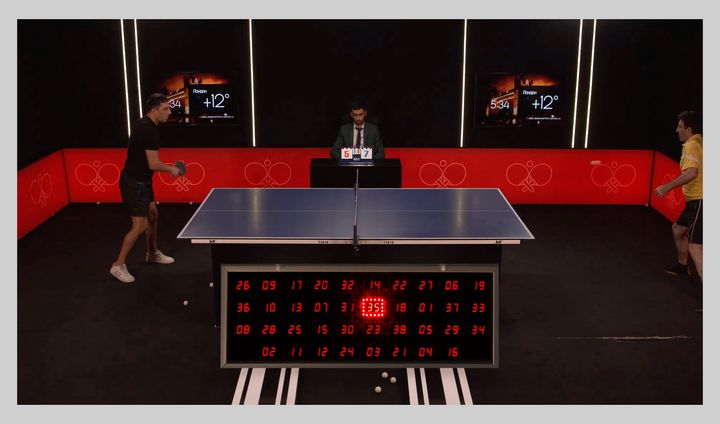 Спортсмены играют в настольный теннис, а под столом находится электронное табло, по которому перемещается курсор и подсвечивает числа